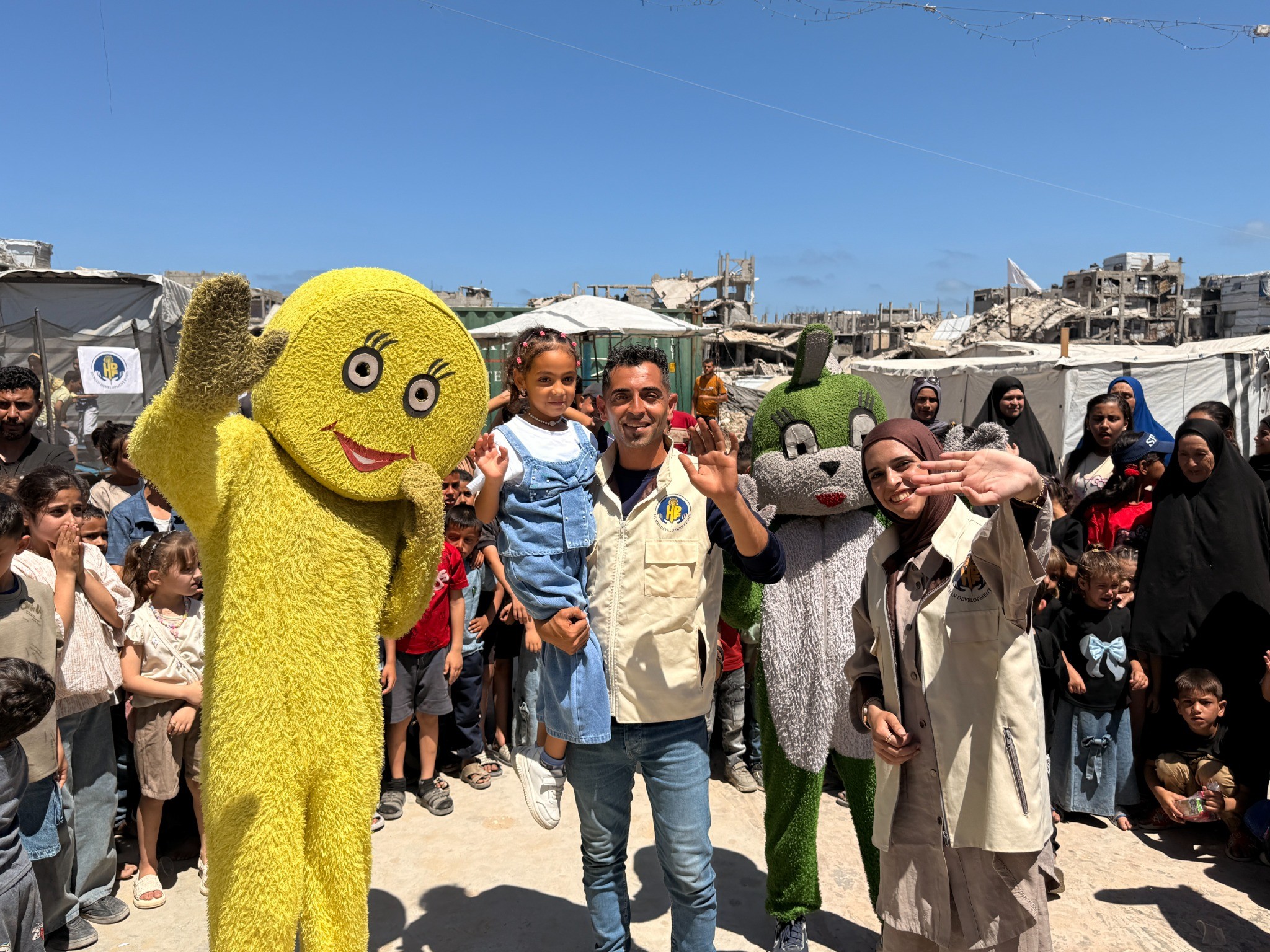 HDF team members, children and costumed characters gather at a community activity in Gaza in 2026